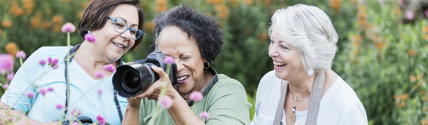 Three Senior Women with Cameras in Garden